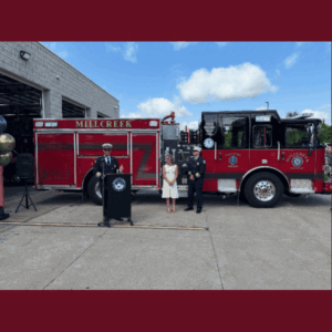 Slideshow of photos of firefighters speaking at podium and pushing fire engine into station.