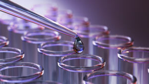 Test tubes in a laboratory with a drop of liquid added to a test tube